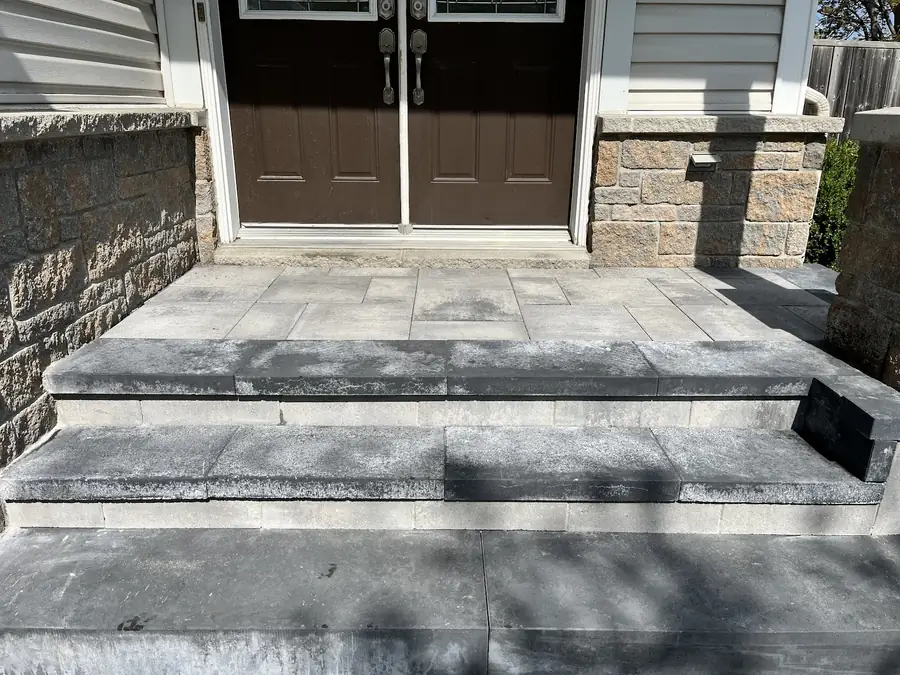 Wide grey stone steps rising to a pair of brown double doors